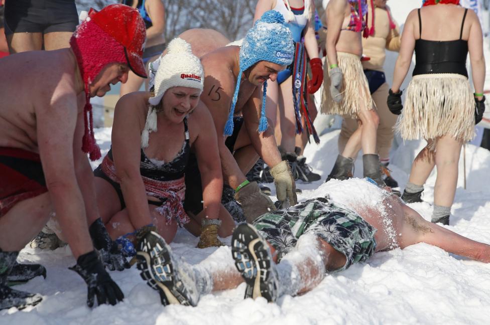 people cover a man with snow during a snow bath at the quebec winter carnival in quebec city