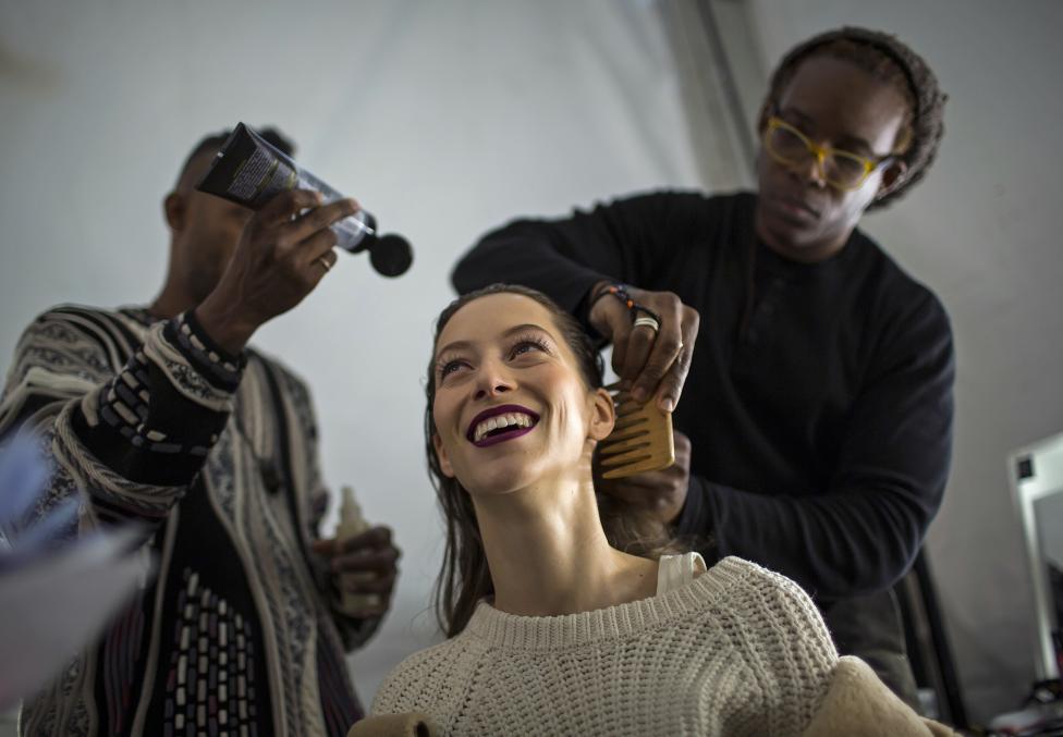 A model is made up backstage before the Carolina Herrera Fall/Winter 2015 collection show during New York Fashion Week