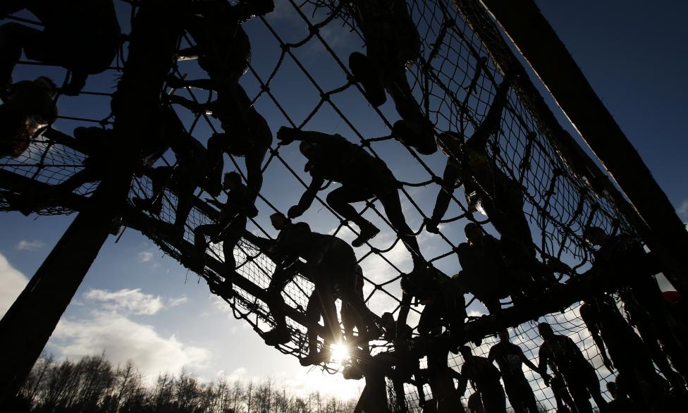 competitors cross a cargo net during the tough guy event in perton, central england