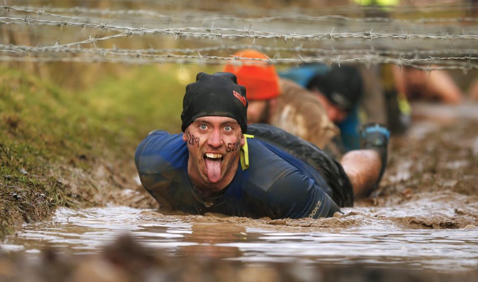 13 Photos From The 2015 Tough Guy Race A competitor gestures as he crawls beneath barbed wire during the Tough Guy event in Perton, central England