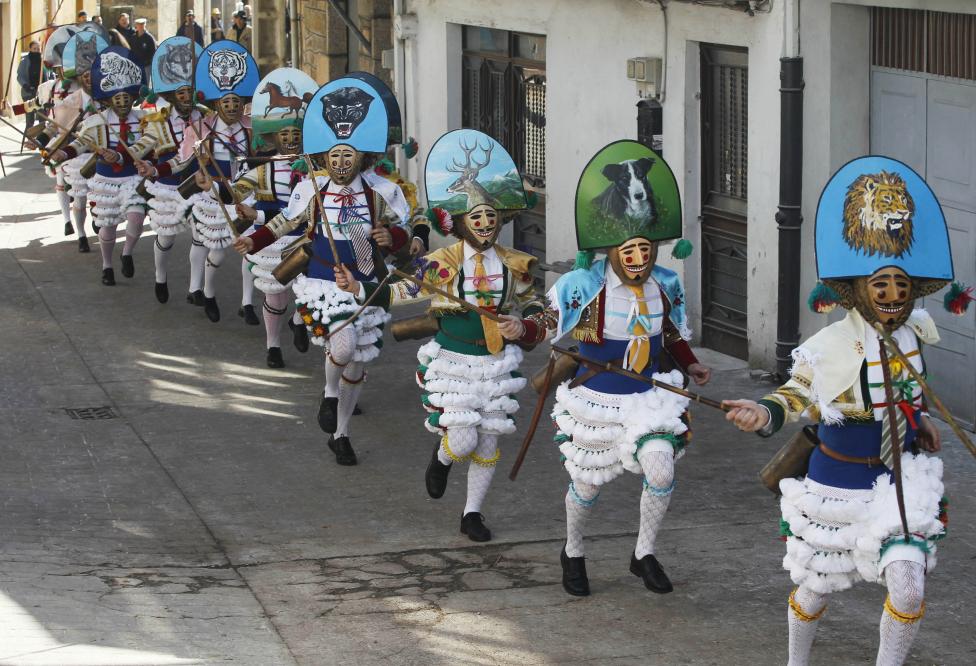 carnival revellers dressed as "peliqueiros" run along a street in spain's northwestern village of laza