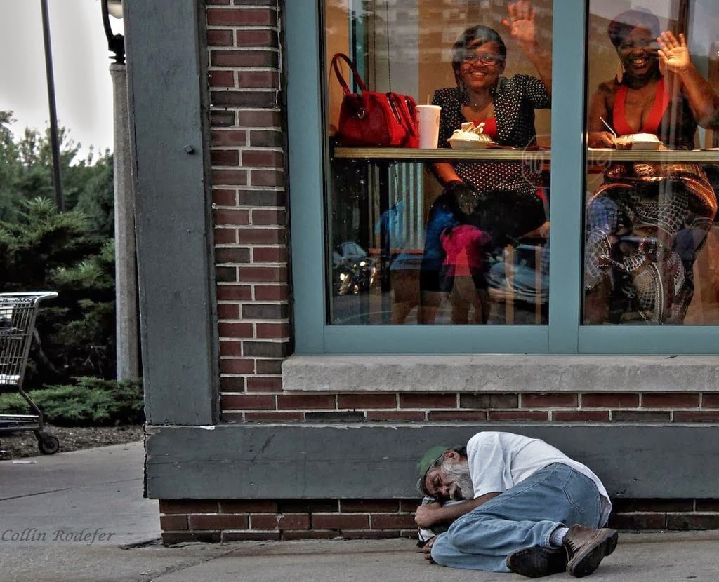 Ignorance is bliss – Homeless man sleeps outside a diner in Milwaukee.