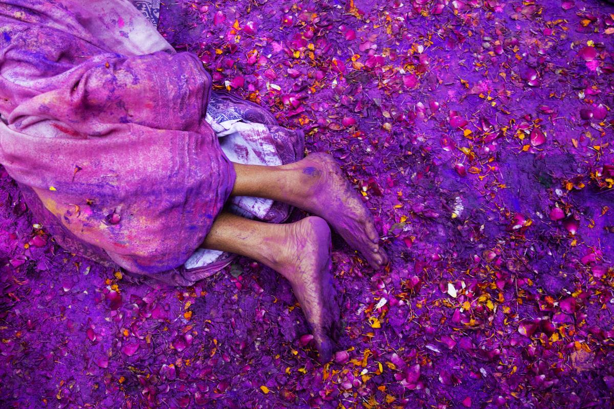 A Hindu widow lay on a sludgy ground filled with a mixture of colored powder, water, and flower petals during celebrations to mark Holi at the Meera Sahabhagini Widow Ashram in Vrindavan, India. (Bernat Armangue/Associated Press)