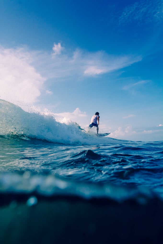 Photographer Karl Lundholm Captures Beautiful Seascapes of Australia surfer riding a wave in uluwatu, bali