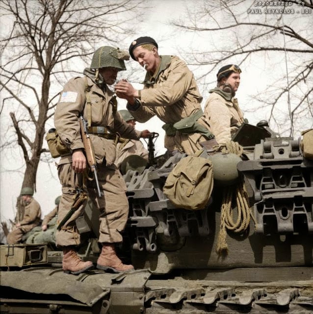 A paratrooper from the American 17th Airborne Division gets a light from a Churchill tank crewman of 6th Guards Armoured Brigade near Dorsten in North Rhine-Westphalia, Germany, 29th of March 1945. (Source - No 5 Army Film & Photographic Unit - © IWM BU 2738. Photographer - Sgt.Midgley. Colorized by Paul Reynolds. Historic Military Photo Colourisations)