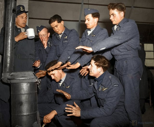 The crew of Avro Lancaster "C for Charlie" of No. 44 (Rhodesia) Squadron RAF, try to warm themselves in their Nissen hut quarters at Dunholme Lodge, Lincolnshire, England, after returning from a raid on Stuttgart, 2nd of March 1944. (Source - © IWM (CH 12379. Colorized by Paul Edwards)