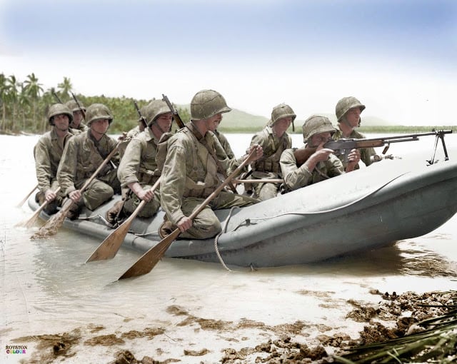 A Browning Automatic Rifle (BAR) man in the bow of the rubber landing craft provides covering fire as a 10-man boat crew of the US Marine 3rd Raider Battalion reaches the undefended beach of Pavuvu in the Russell Islands during 'Operation Cleanslate'. February 1943. (Source - USMC ID #: 54765. Colorized by Royston Leonard UK)