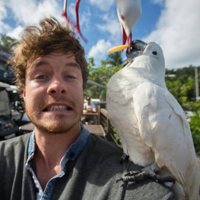 a man standing in front of a parrot