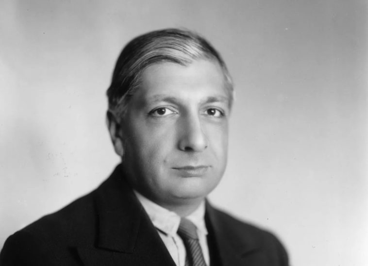 a man wearing a suit and tie posing for a photo