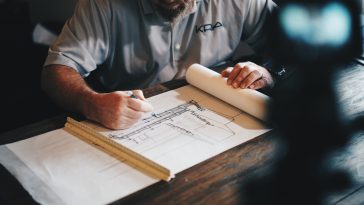 an architect working on a draft with a pencil and ruler