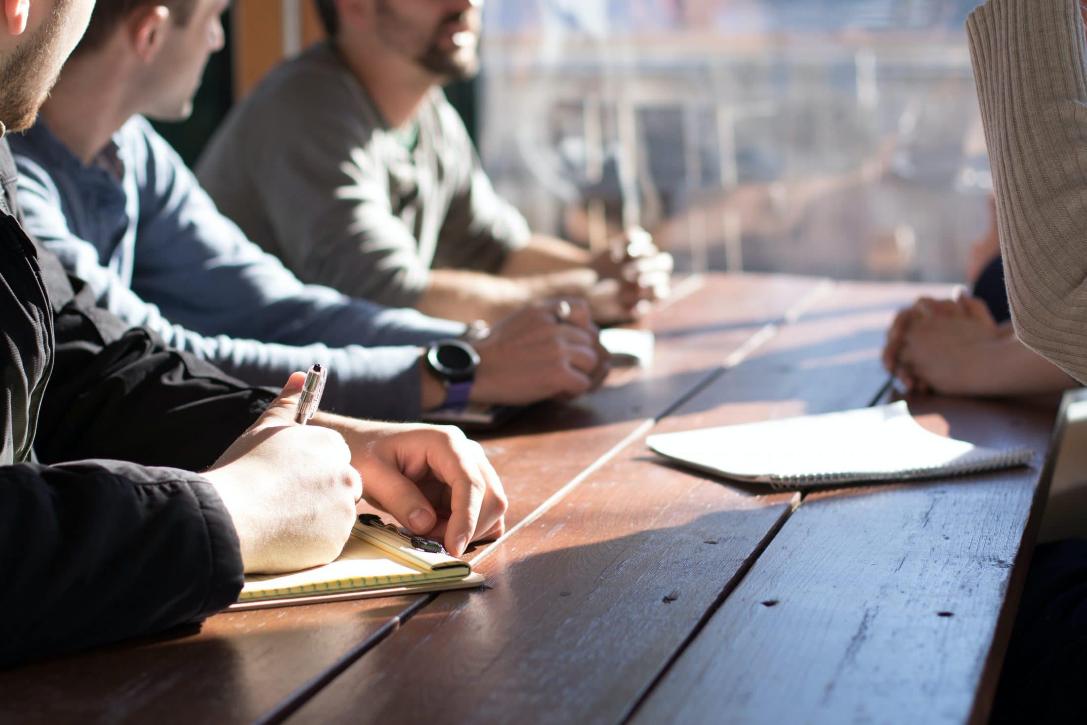 What Goes Into Starting a Construction Company? people sitting on chair in front of table while holding pens during daytime