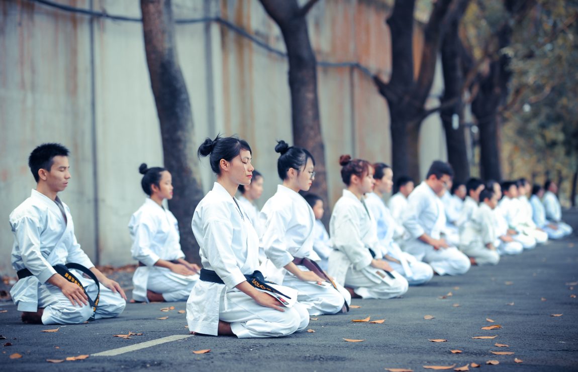 Chinese people group of martial artists sitting on the grounds