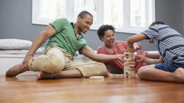 family on the floor playing a game at home.