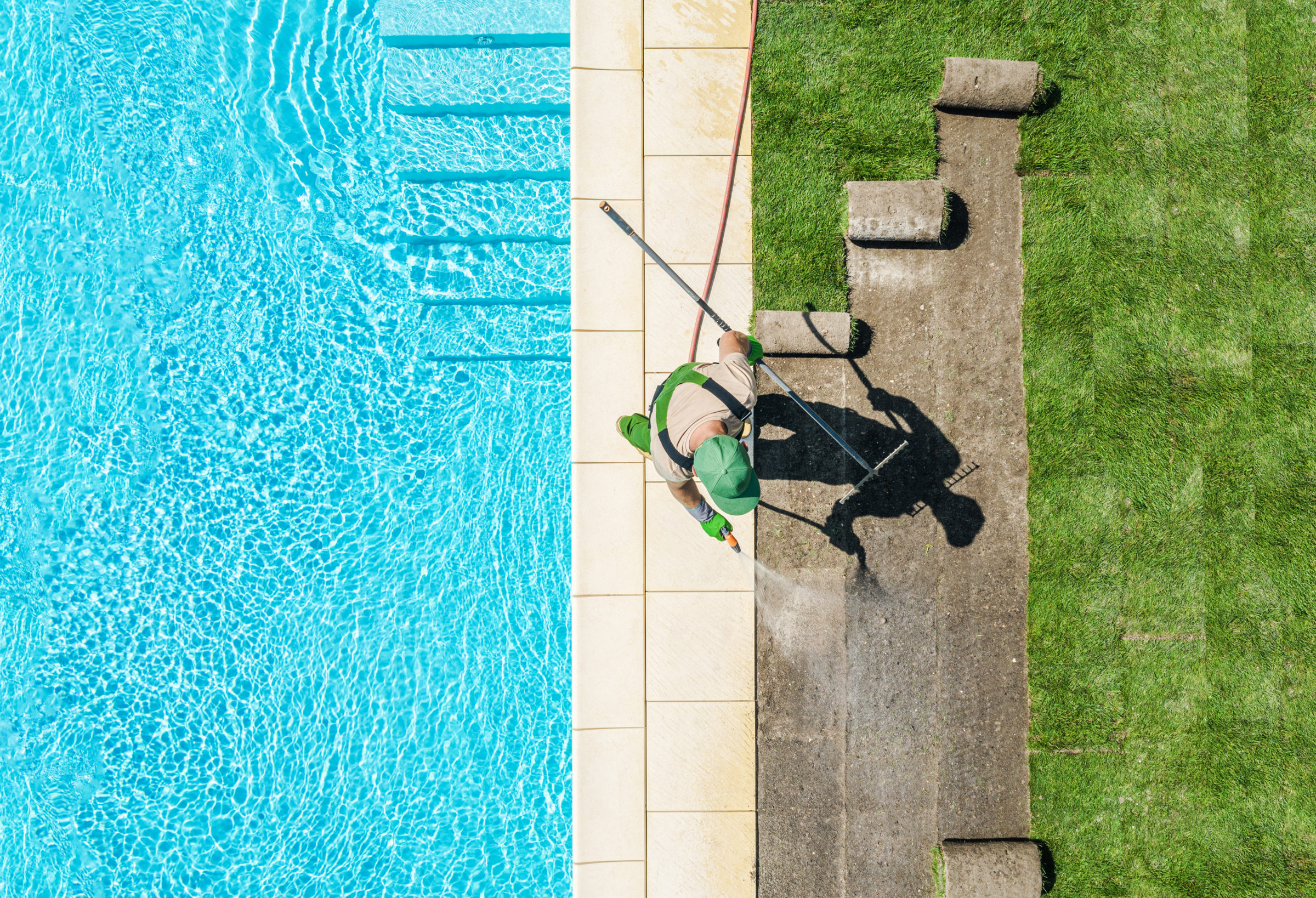 gardener finishing lawn around swimming pool 5V9983H