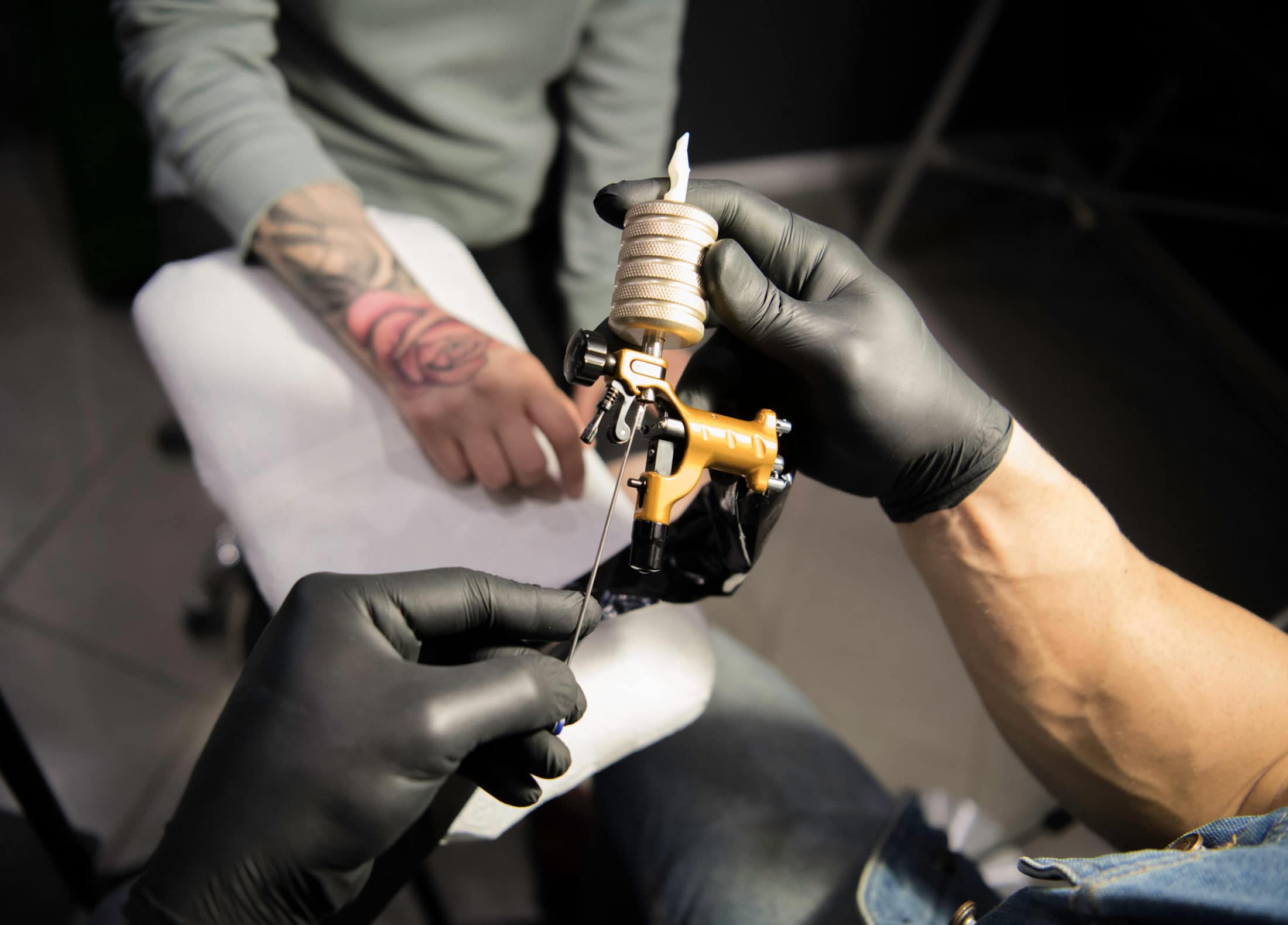 close up of the hands of tattoo master preparing f H77XA22 scaled