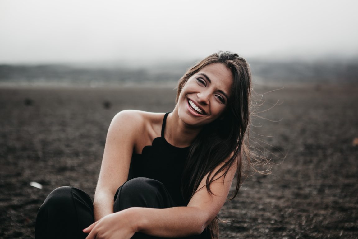 woman laughing while sitting on ground