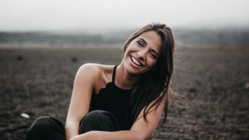 woman laughing while sitting on ground
