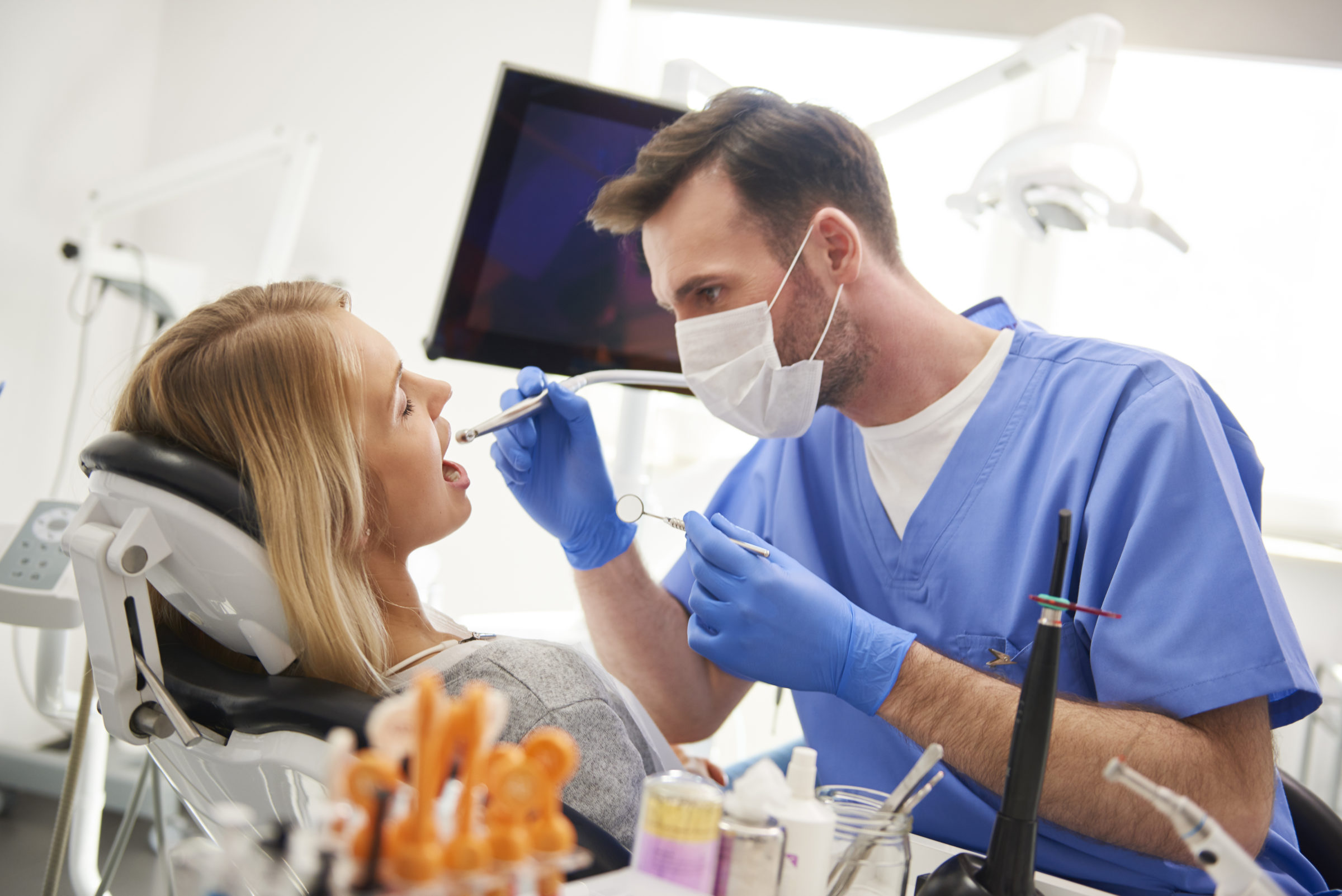 focused dentist using dental drill and dental mirr XBN2CA2