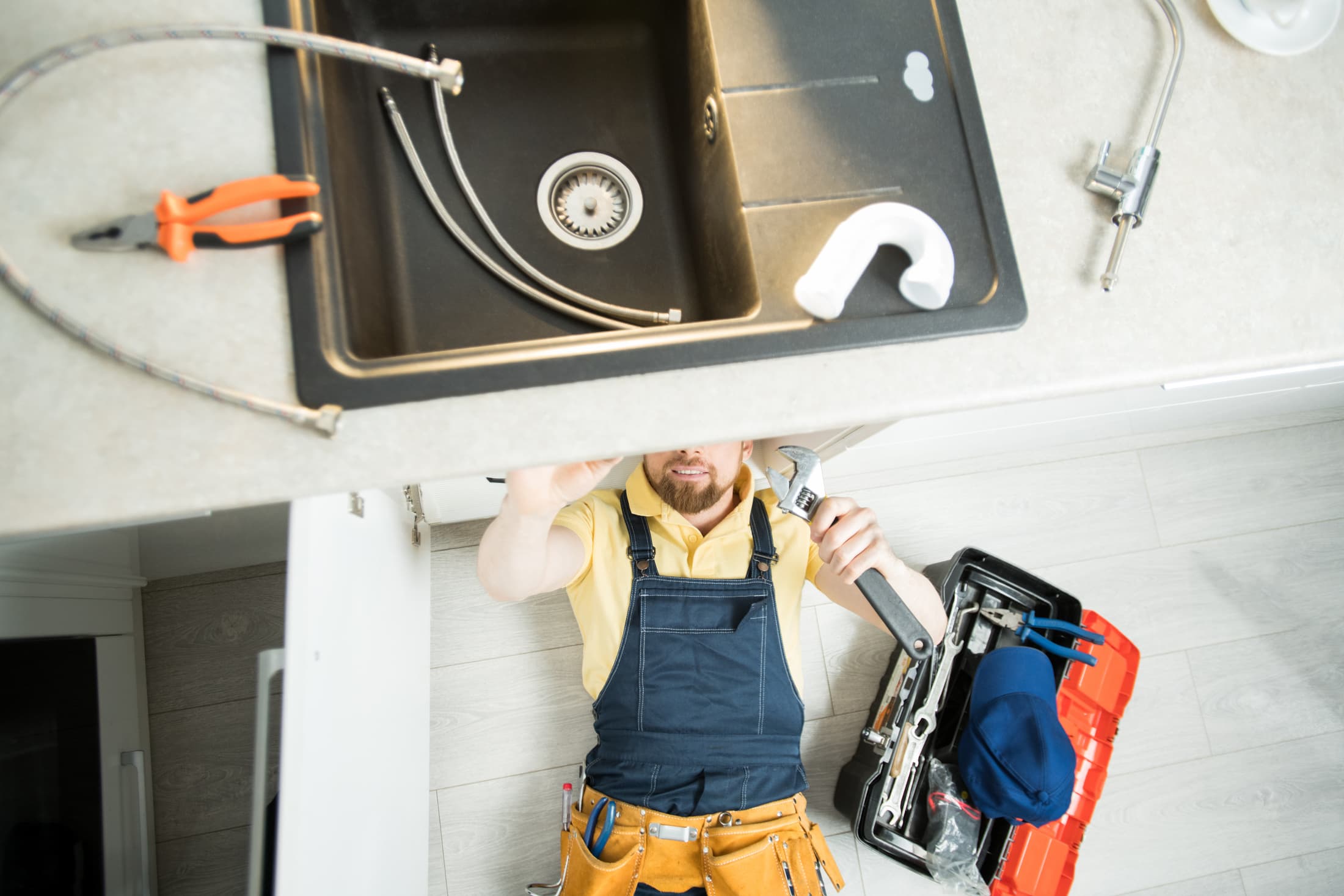 Plumber Repairing Pipe In Kitchen 6K7VBFA 