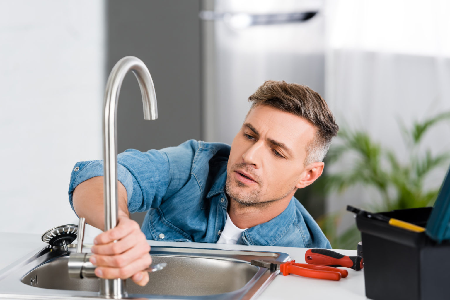 repair man gets woman at kitchen sink