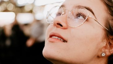 selective focus photography of woman wearing eyeglasses looking up