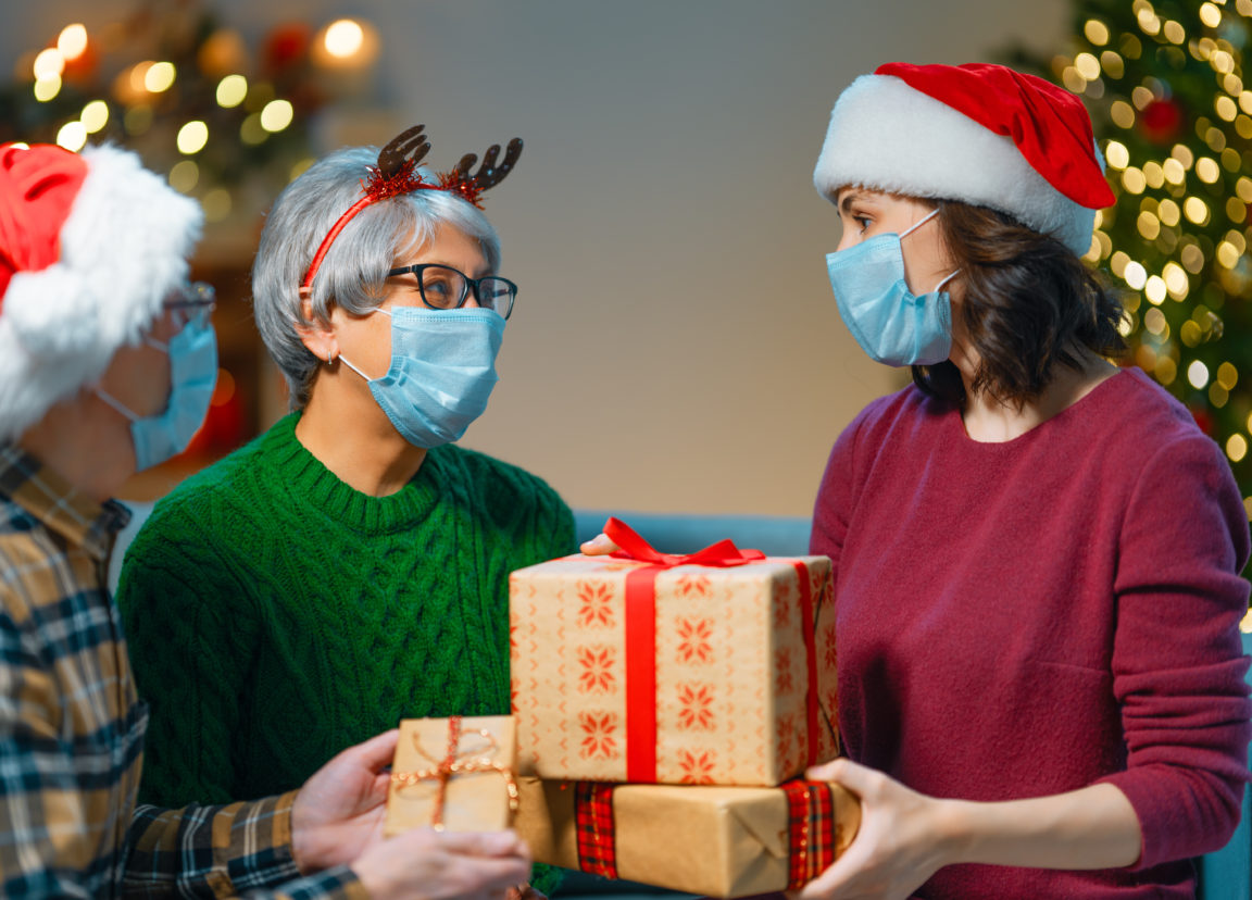 people with gifts wearing facemasks on christmas NP774VV