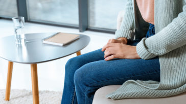 cropped shot of young woman sitting on couch durin ZPV2QNY