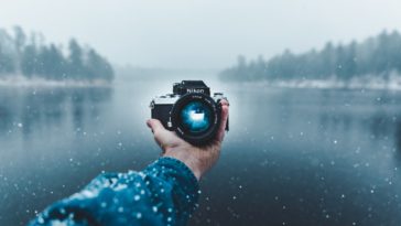 person taking selfie using nikon dslr camera