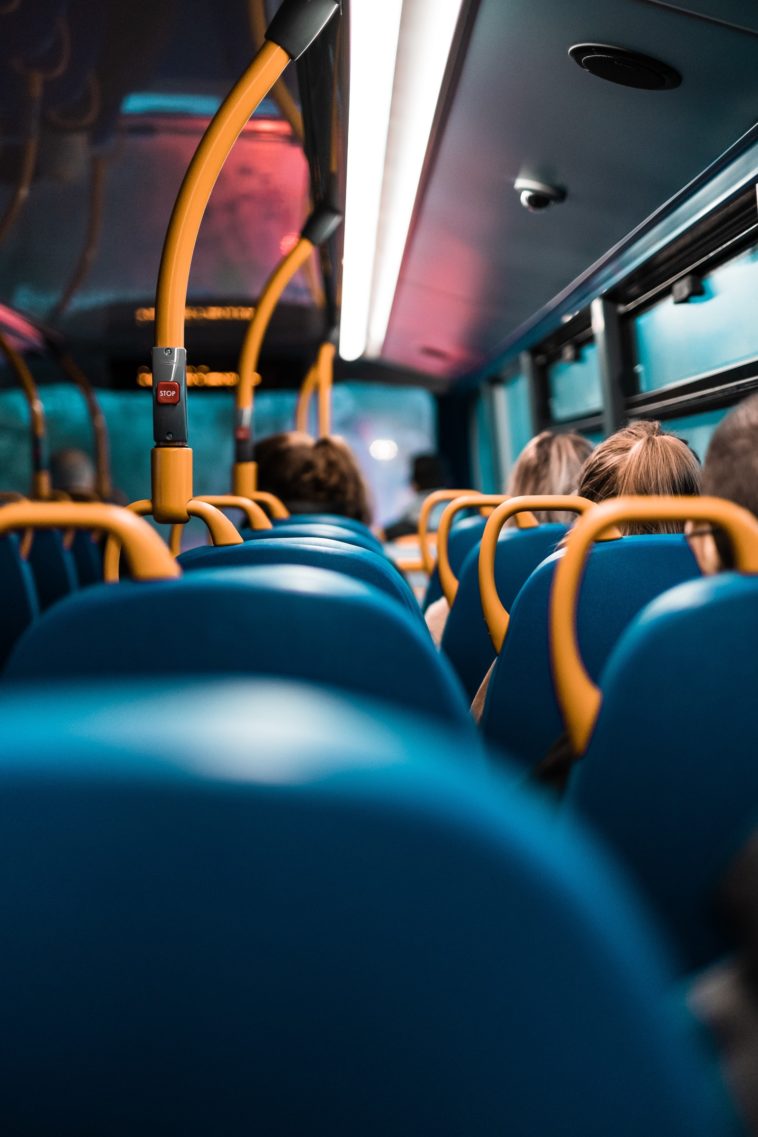 people sitting on blue and yellow bus seats