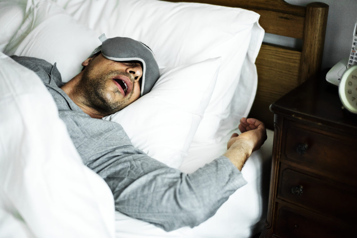 a man sleeping on a bed 54F2XGK