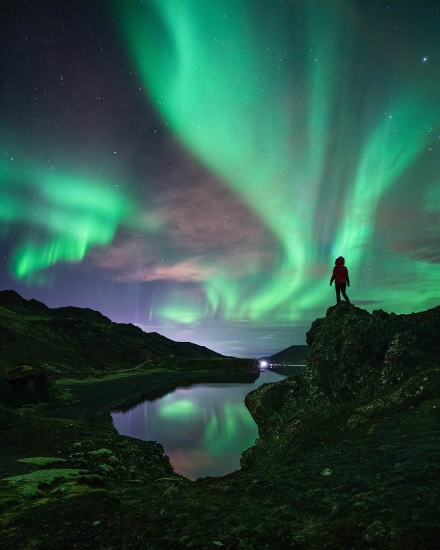 Aurora borealis on the Norway. Green northern lights above mountains. Night  sky with polar lights. Night winter landscape with aurora and reflection on  the water surface. Natural back Stock Photo