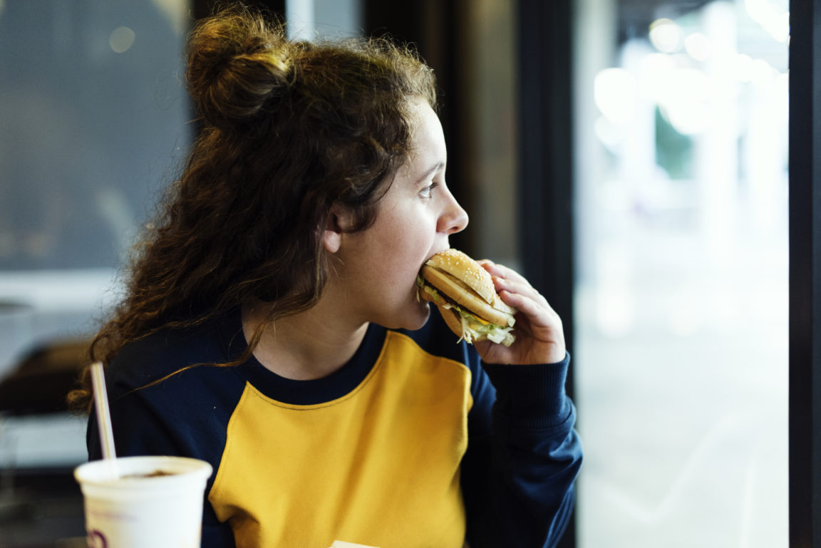 close up of teenage girl eating hamburger obesity 2021 08 27 00 03 31 utc