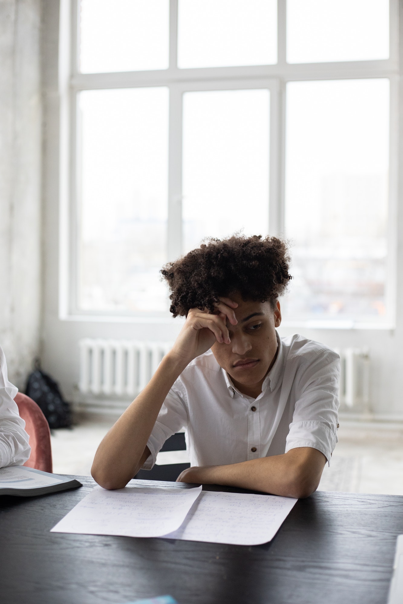 10 Easy Ways to Make Essays Longer with Words pensive black man working on essay in light room