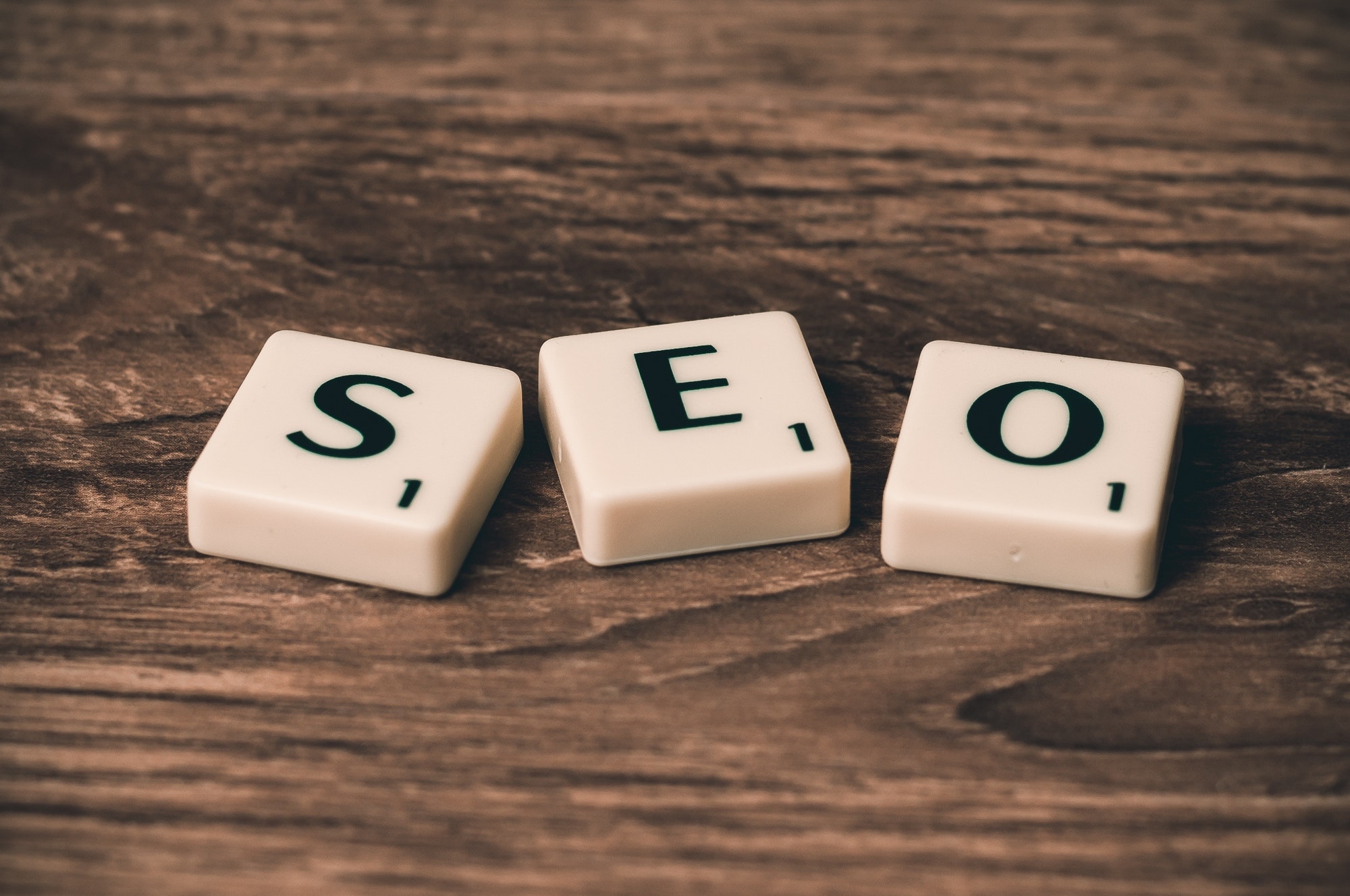How To Use SEO To Improve Your Brand Identity three white-and-black scrabble tiles on brown wooden surface