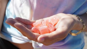 person holding orange medicine tablets