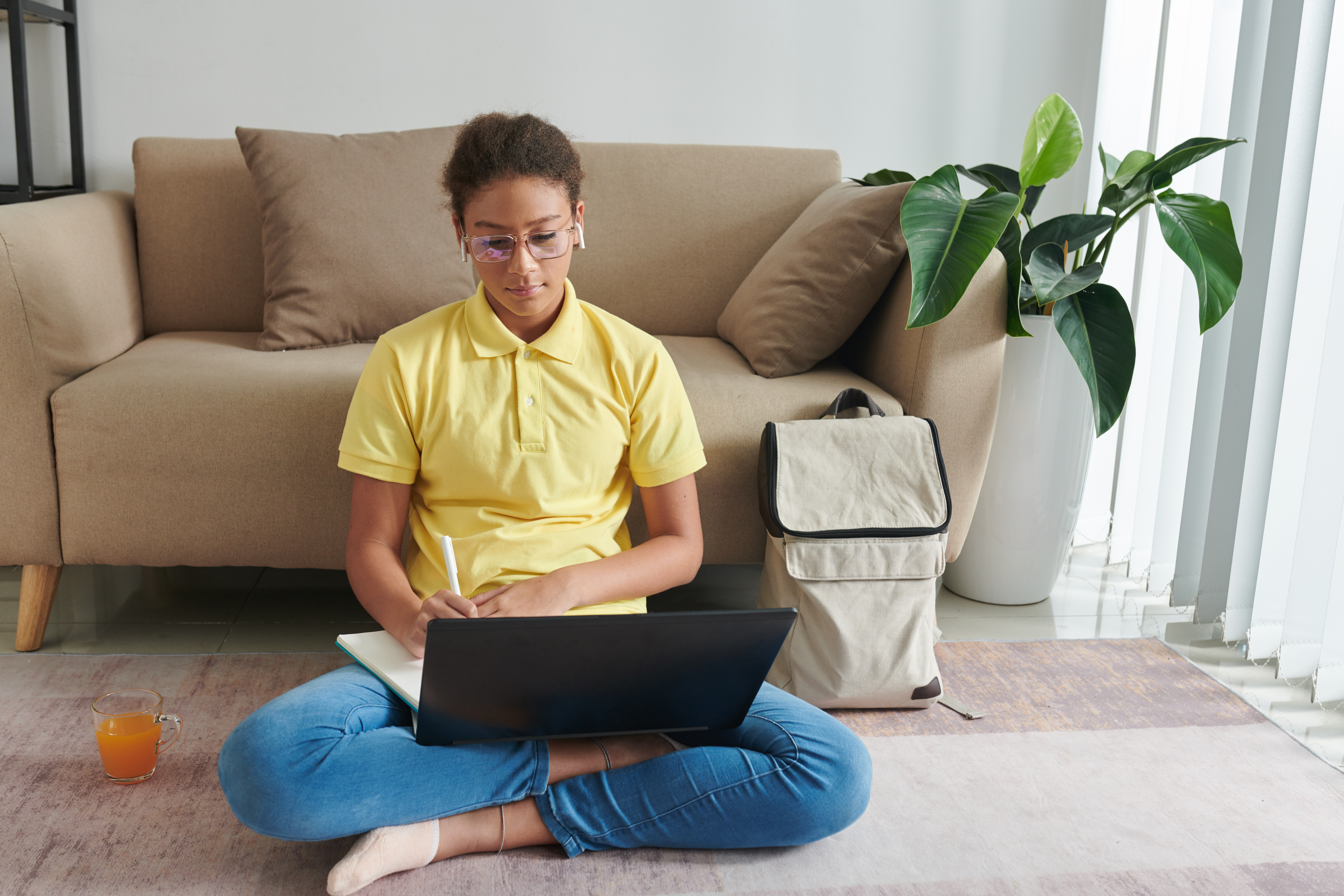 a person sitting on a couch using a laptop
