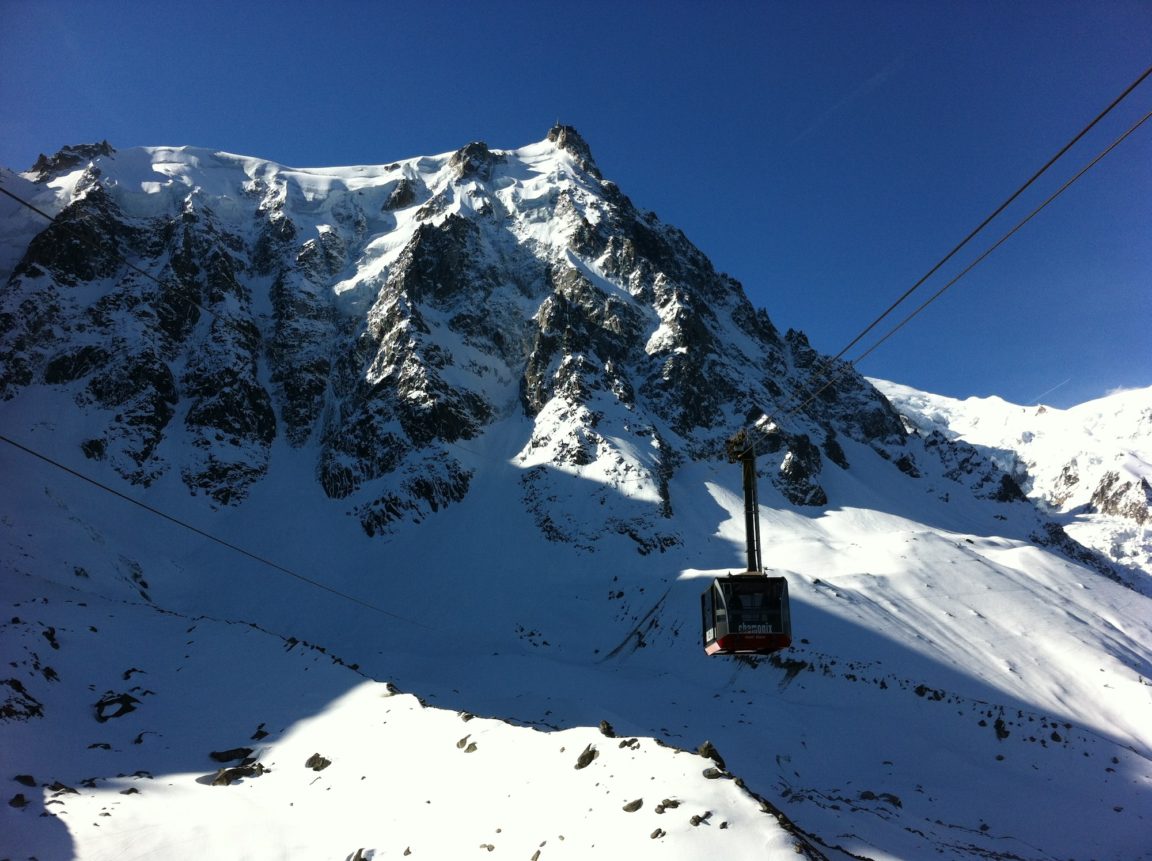 a man flying through the air on a snow covered mountain