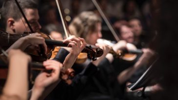 people playing violin inside dim room