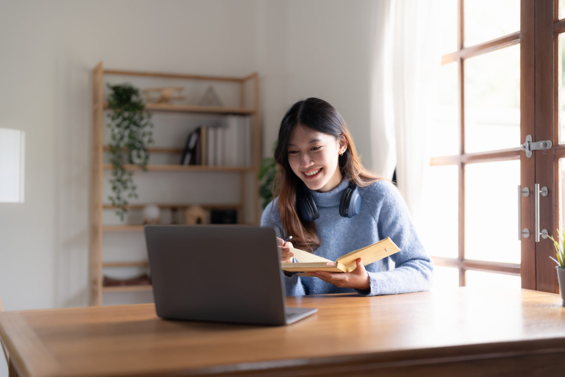 a person sitting at a table using a laptop