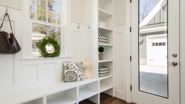 gray and white floral throw pillow beside rack inside room