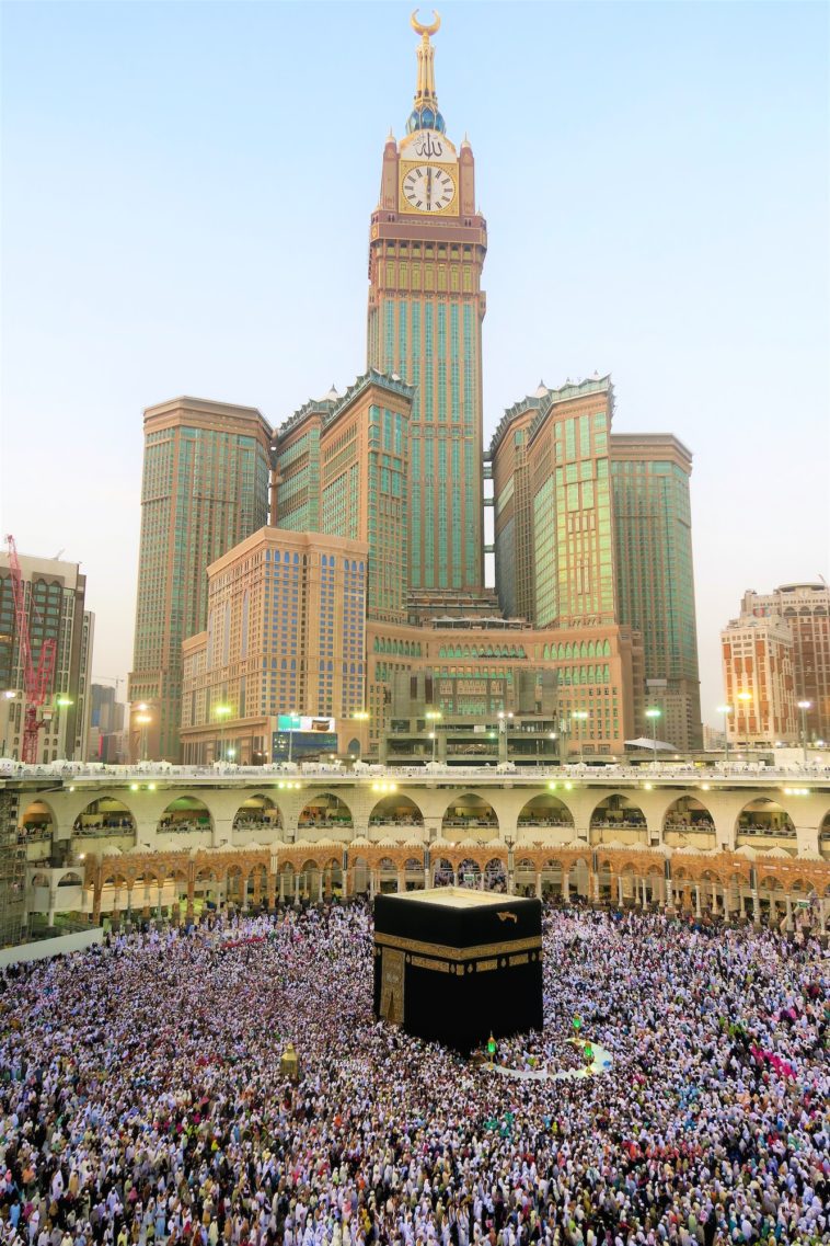 a group of people standing in front of abraj al bait