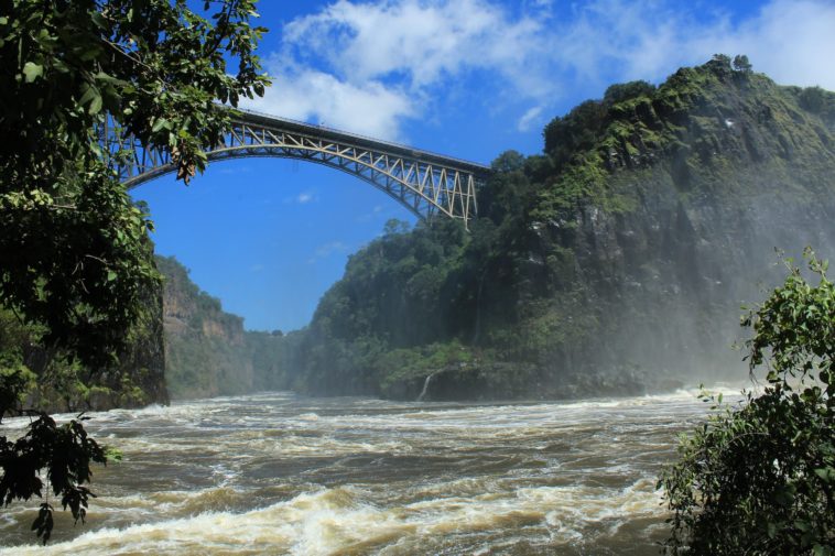 a bridge over a river with a waterfall below