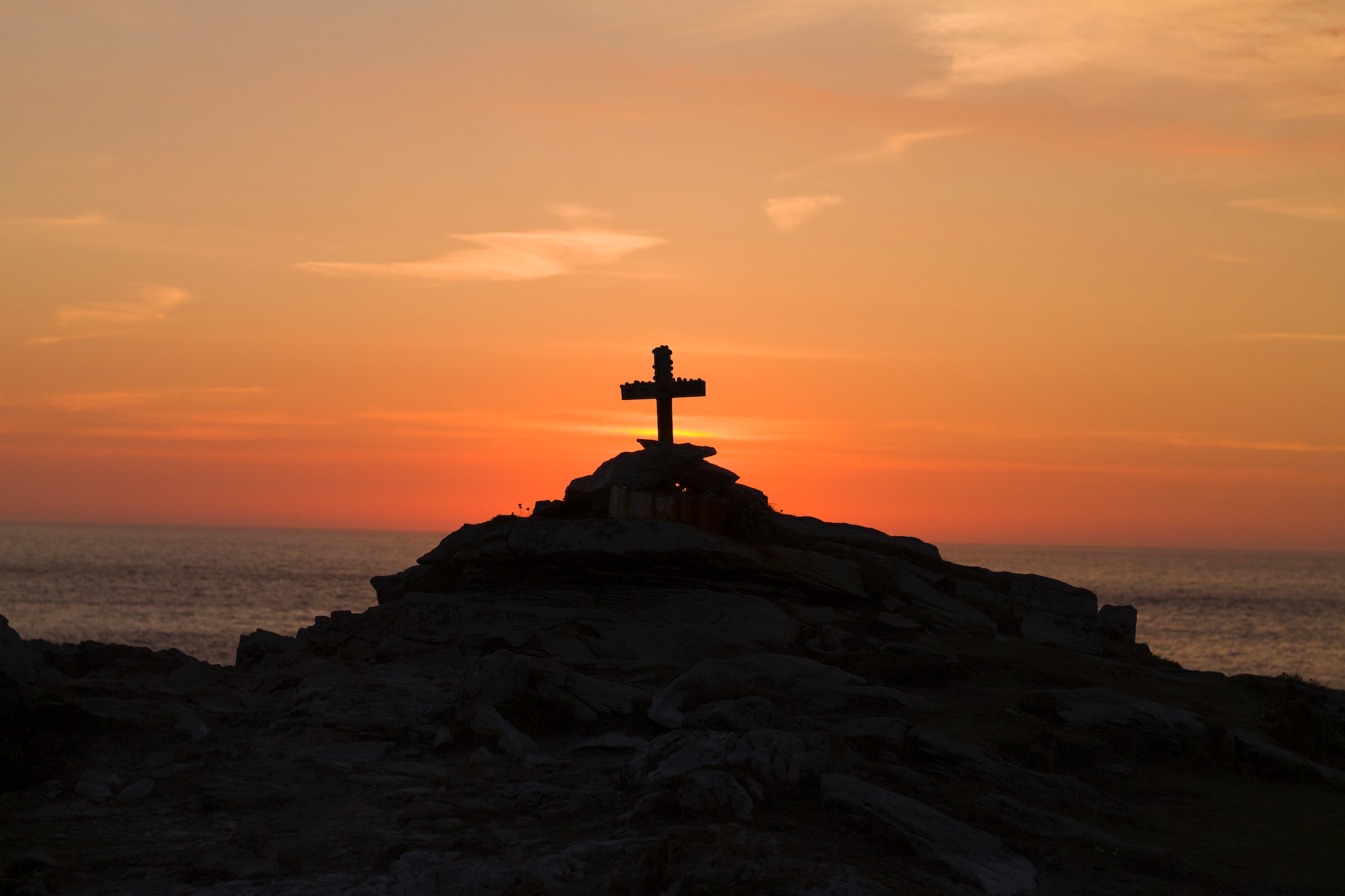 Christian cross silhouette on mountain during golden hour