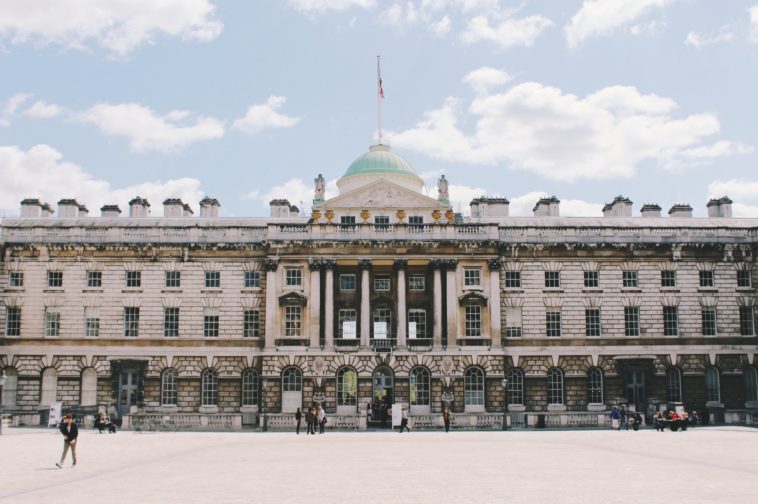 a group of people in front of a large building with somerset house in the background