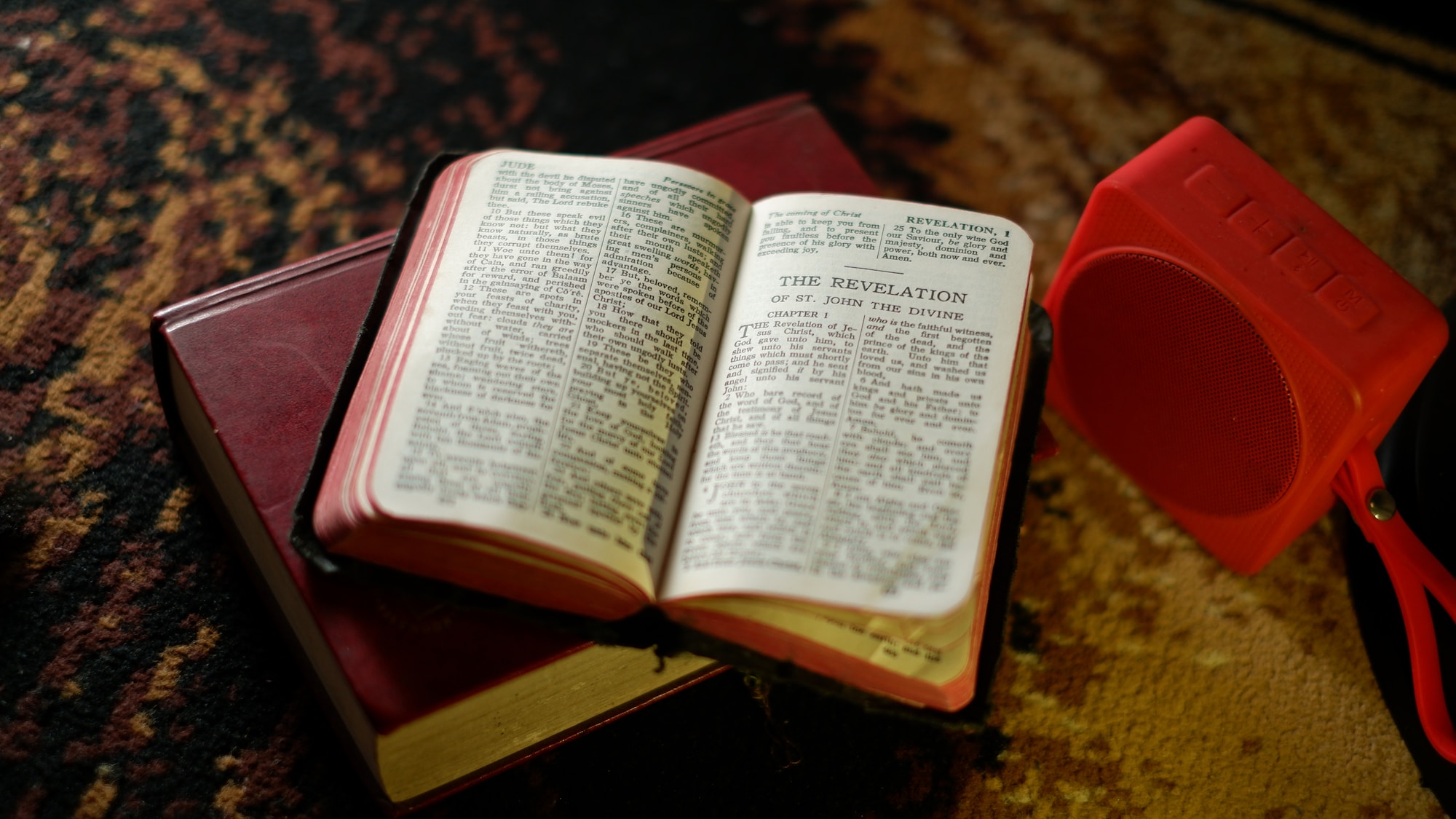 Apocalypse an open book sitting on top of a table next to a red speaker