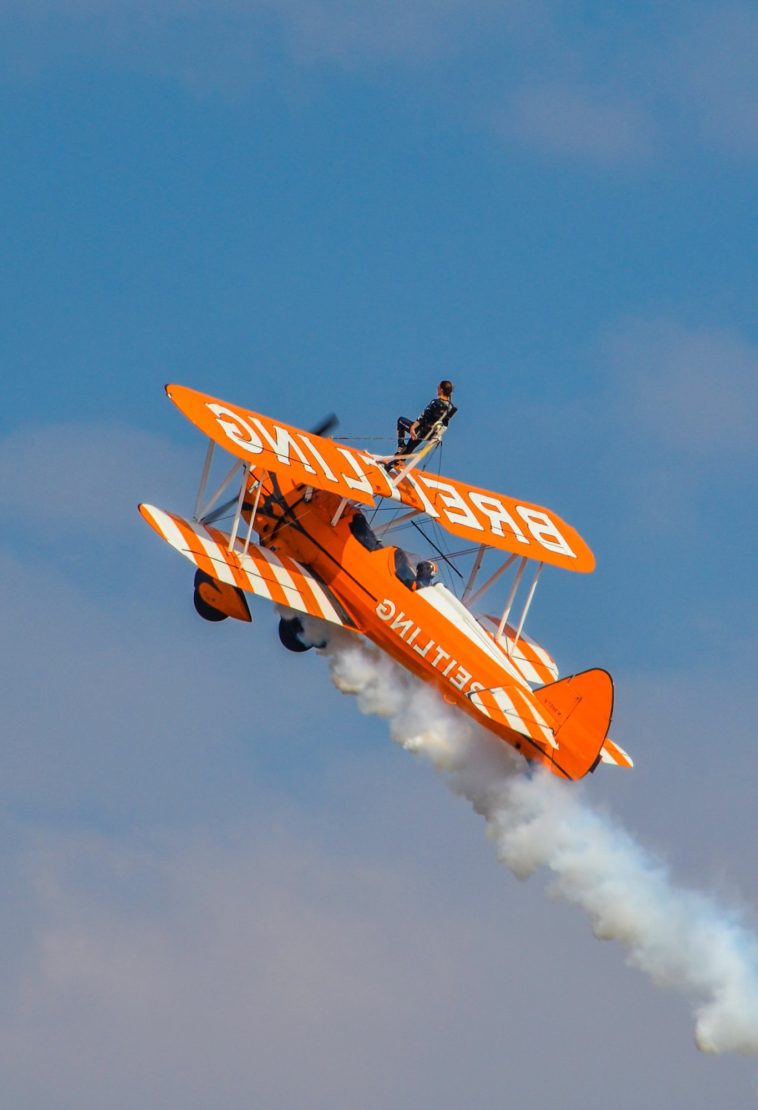 a plane flying in the air with smoke coming out of it