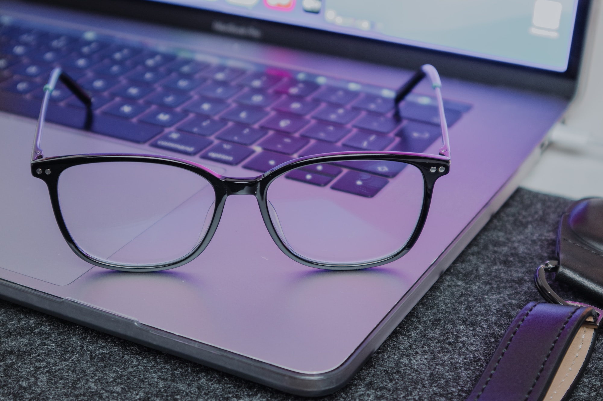 a pair of glasses sitting on top of a laptop